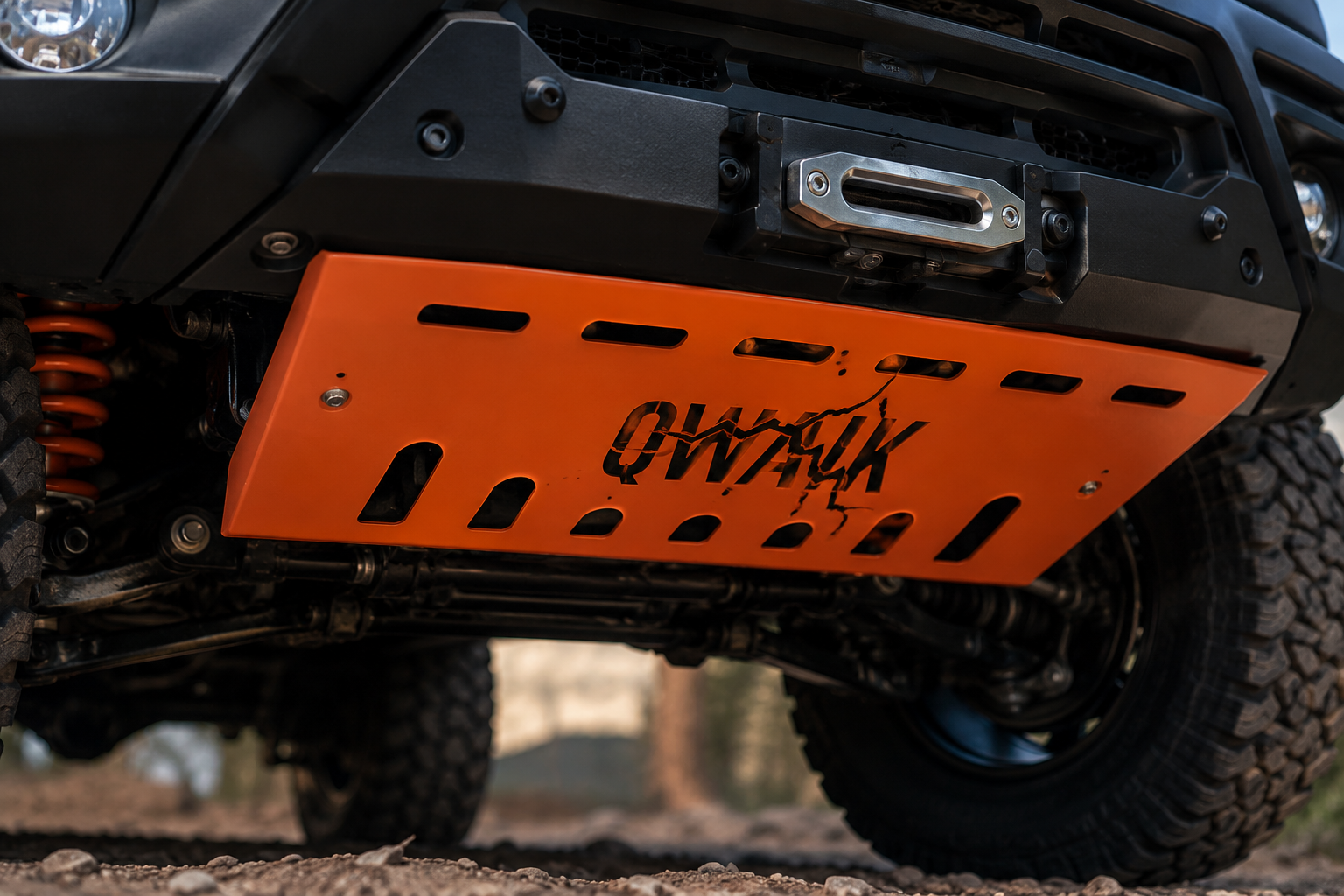 Orange steel skid plate with the QWAIK crack logo laser-cut out of it